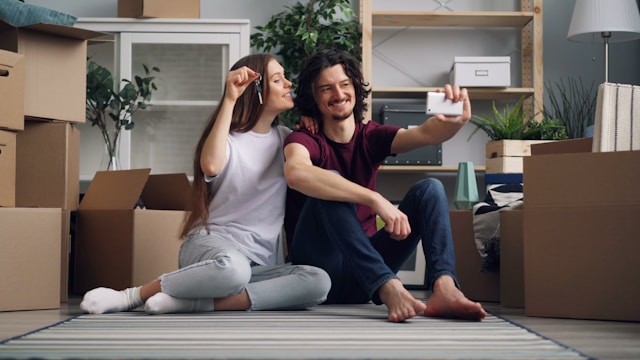 A happy couple taking a selfie in their new apartment